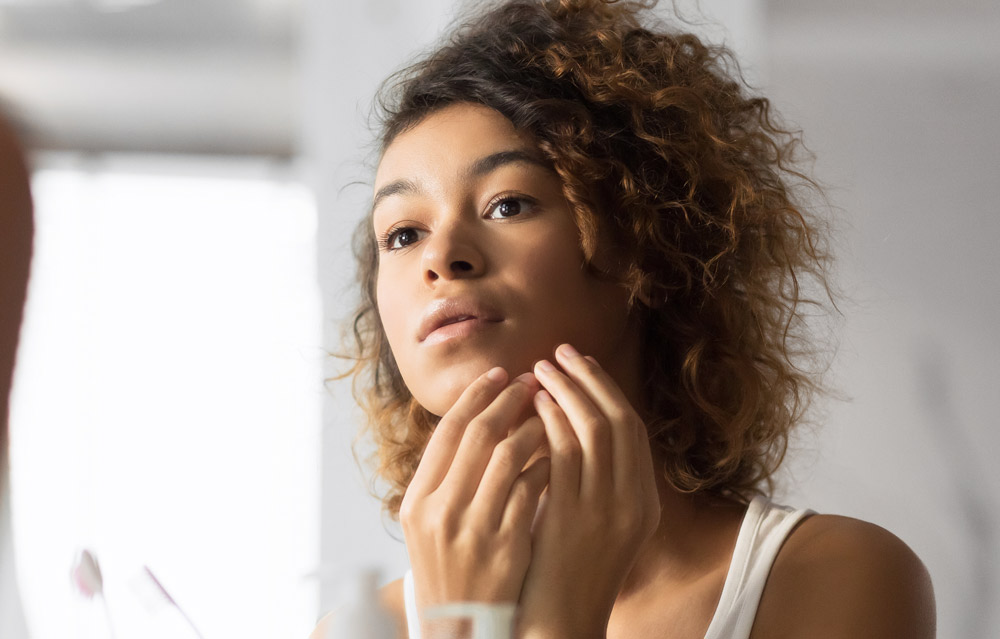 Black Millennial Girl Looking At Pimple In Bathroom