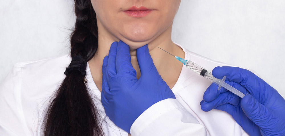 Doctor gives lipolytic injection to a caucasian girl's double chin on a white background, medical, close-up