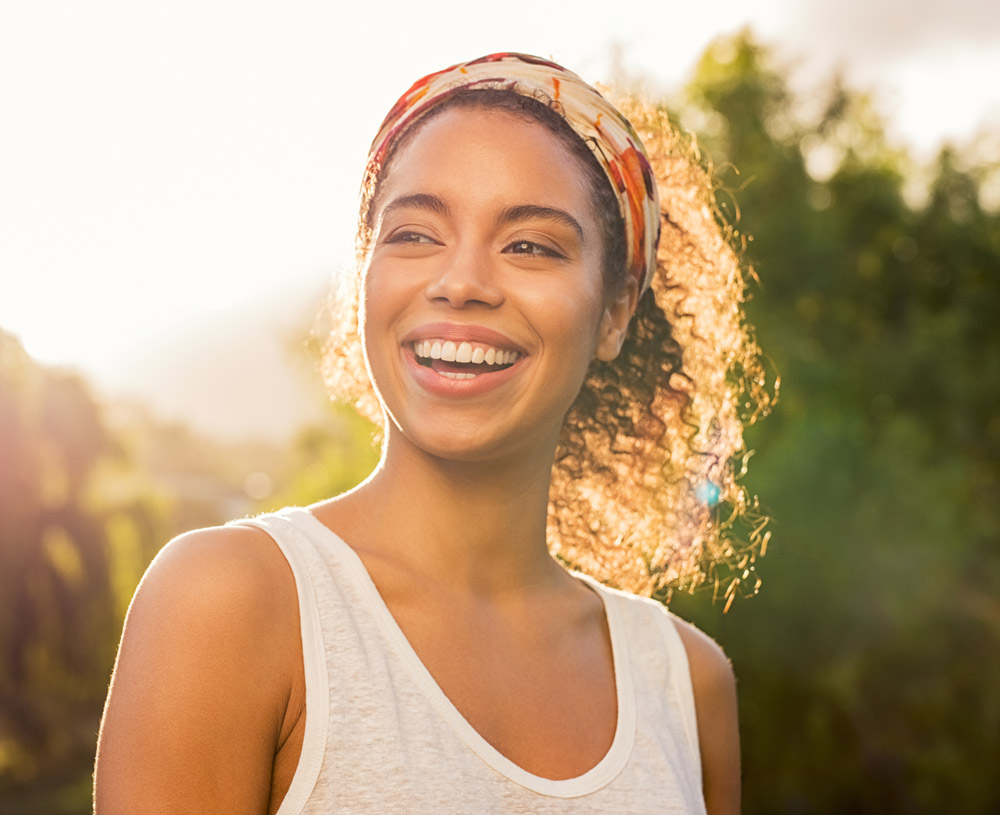 Young black woman smiling at sunset