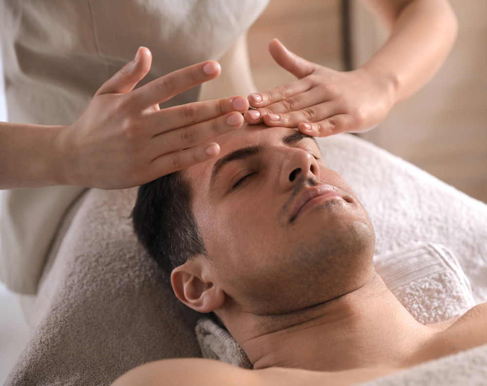 Man receiving facial massage in beauty salon